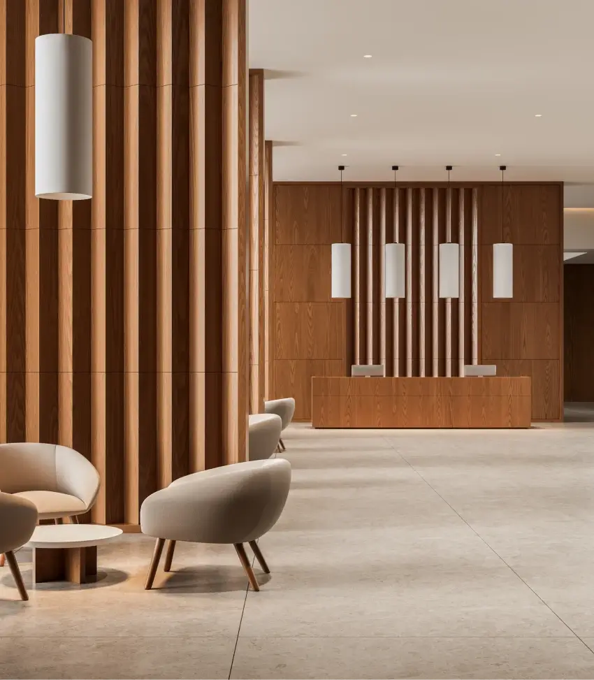 Modern hotel lobby with warm wood paneling, pendant lighting, and contemporary lounge seating